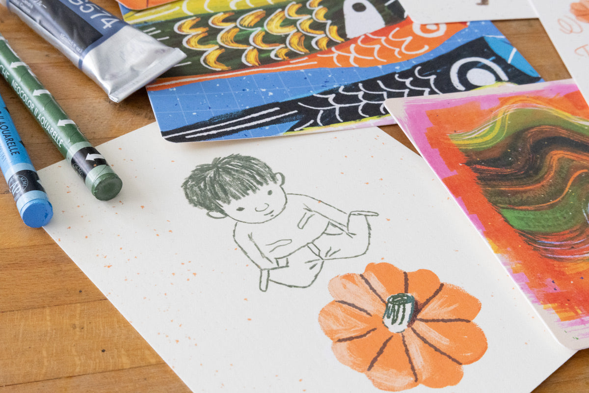 Illustrated postcard of a child holding a pumpkin, shown with crayons